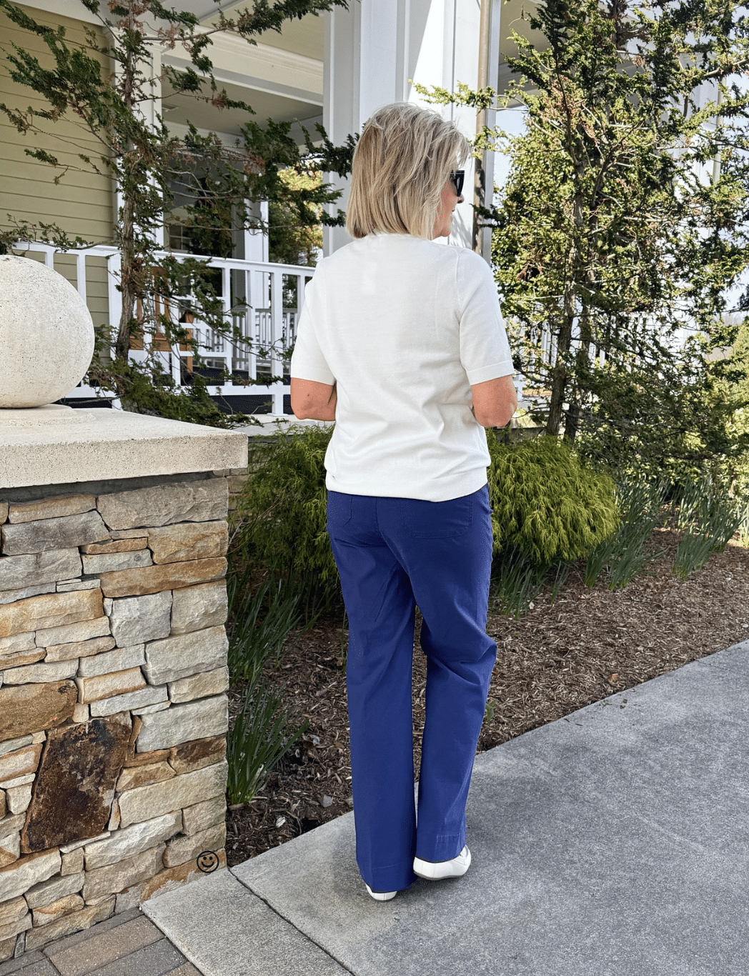 Tania Stephens sowing the back of a white short sleeve sweater and navy patch pocket pants from J.Crew Factory
